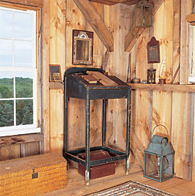 A nineteenth-century schoolmaster's desk, with early ledger and writing implements, occupies a corner of the barn near the owners' cache of research books. On the floor is an early lantern and faux-painted dome-top box.