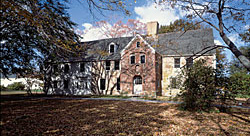 Fig. 2: Spencer-Peirce-Little Farm, Newbury (Historic New England) Colonel Daniel Peirce built this unusual grand stone manor house in about 1690 (the two-story brick entry porch dates to the 1790s). The cruciform plan provides two rooms flanking a center chimney, with a service ell on the back. A National Historic Landmark, it is one of the best preserved examples of its type; the most closely related surviving structure is Bacons Castle (1665) in Surry, Virginia. Still a functioning farm, the fields have continuously produced commercial crops since John Spencer purchased its four hundred acres in 1635.