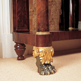 Ormolu is an eighteenth-century English term for applying finely ground, high-karat gold to an object in bronze but it can also refer to lacquered brass resembling gold in appearance and used to ornament furniture, moldings, architectural details, and jewelry. Ormolu often adorned classical furniture as on this early-nineteenth-century mahogany New York pier table. The green shade verde, of the foot, was meant to simulate oxidized bronze to give the appearance of an ancient object uncovered from antiquity.