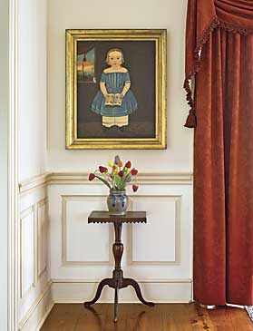 The young girl, by Sturtevant Hamblin, circa 1840s, is identified as Sarah North of Portland, Maine. The glass tulips set into a cobalt decorated stoneware crock are one of several bouquets in the house. The New England square-top candlestand, with sawtooth applied edge, was found in Herkimer, New York, and dates to circa 1820. It was purchased from Sam Herrup.