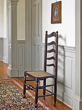 One of two similar ladder-back side chairs with original surface lining the hallway. With its applied skirts, dramatic bulbous turned stretcher, and suppressed ball feet, this chair exhibits a classic Delaware Valley form. Above the chair is one of several profile portraits in the collection, with their classic grey background, dating between the 1810s to 1840s, and attributed to “Mr. Boyd,” of central Pennsylvania. Though his identity is not confirmed, it is possible Mr. Boyd was a portrait and furniture painter working in the Harrisburg area.