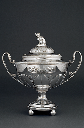 Horse Racing Trophy, William Fountain, London, England, ca. 1803. Inscribed “Roxana Winning a / Jockey Club Purse / at Washington Course / in Charlestown [sic], South Carolina /  Feby [sic], 1802” and bearing the McPherson crest and arms. Silver. H. 16-1/2, L. 15-1/2 in. Courtesy, the Rivers Collection, Charleston, S.C. Photograph provided by the Gibbes Museum of Art. | Among his military and political accomplishments, General John McPherson (1756-1806) was one of the top horse breeders in early America, and one of the twenty who developed the Washington Race Course, so named for the president. Courtesy, the Rivers Collection, Charleston, S.C. Photograph provided by the Gibbes Museum of Art.   